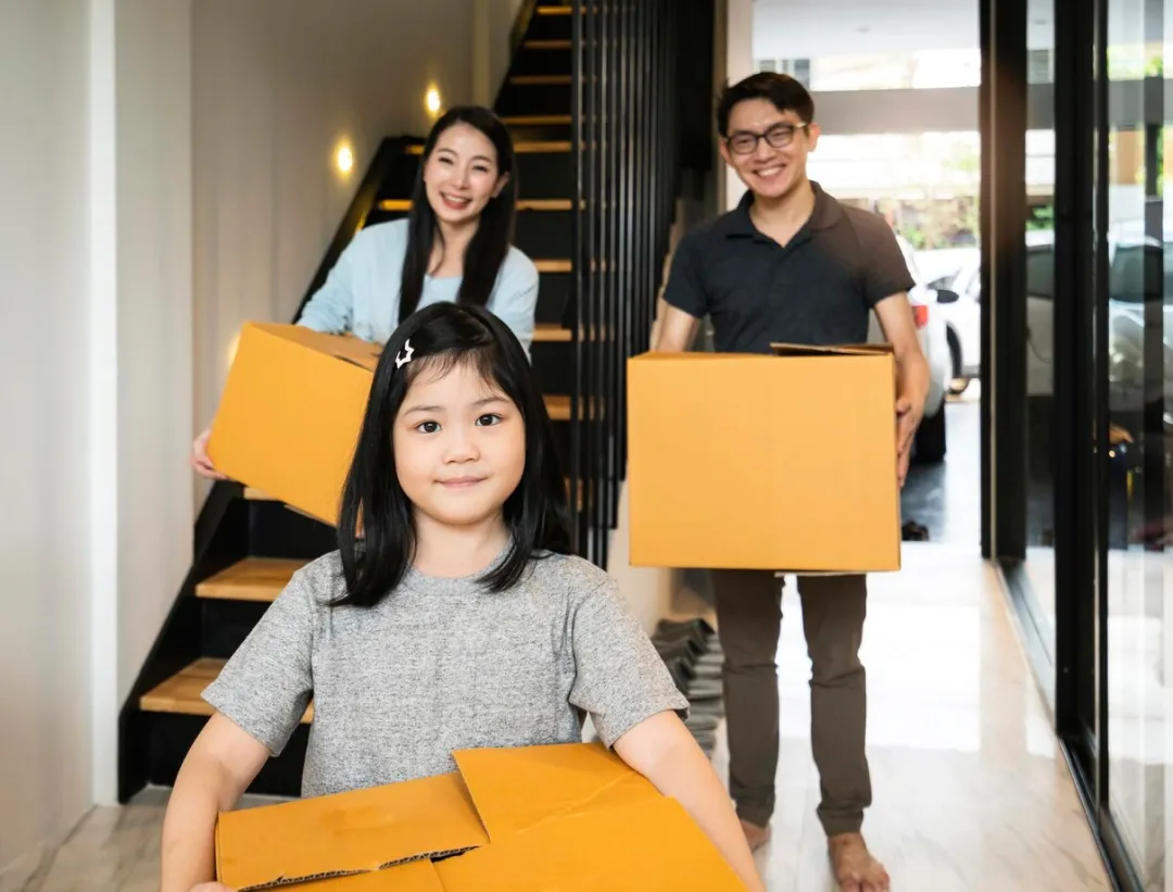 Family carrying moving boxes on moving day