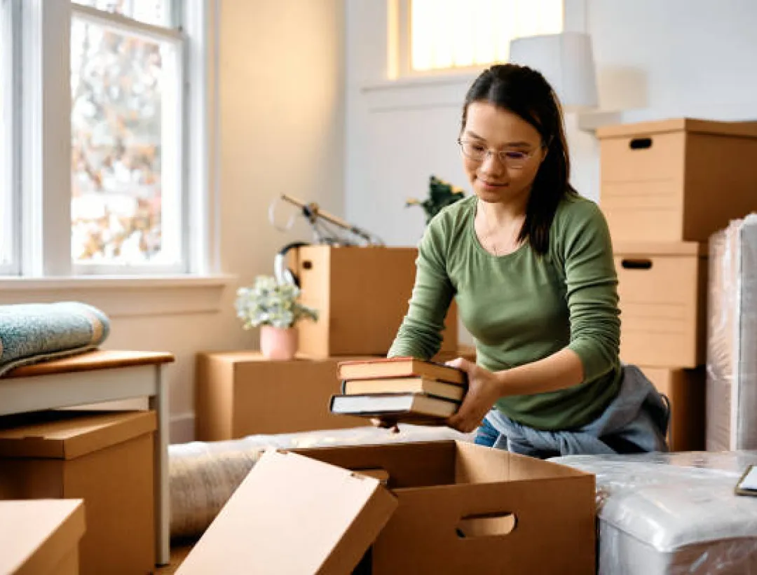 Woman packing books into moving boxes